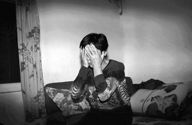 李怀亮的姐姐李爱梅讲述为弟弟的伸冤之路。说到伤心处,双手捂面