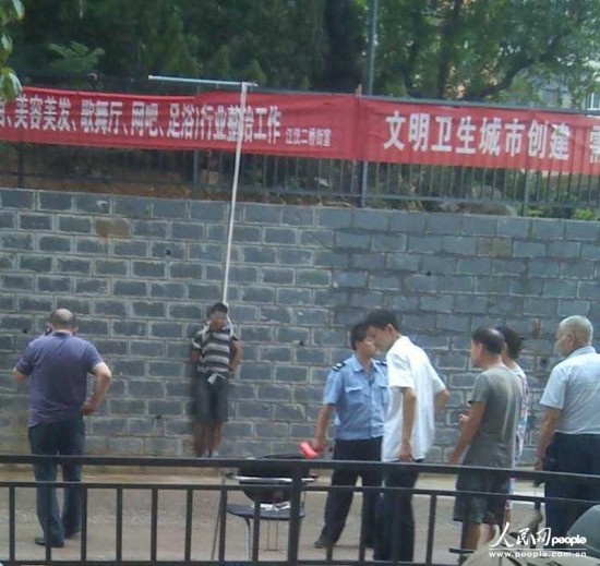 武汉一小偷被示众 双手被反绑吊在高墙栏杆上 图